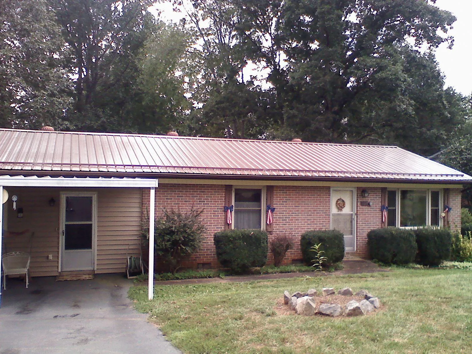 Bronze metal roof and carport on a brick ranch home — Roof Repair work by our crew in Berthoud